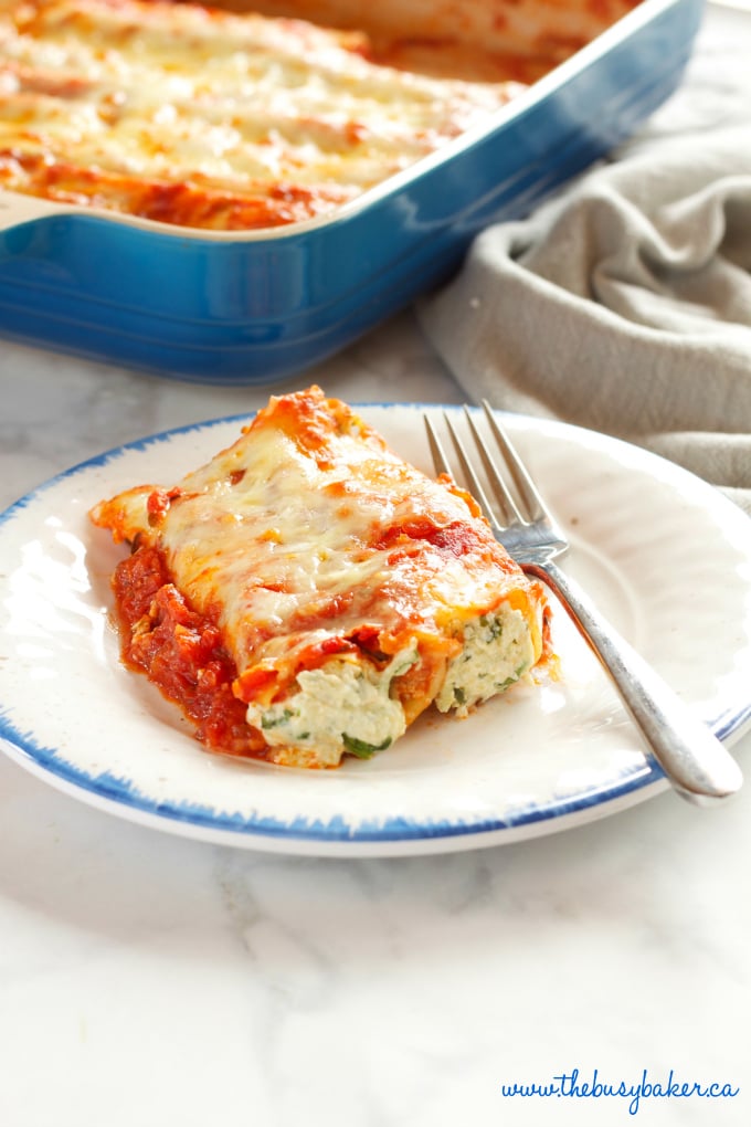 This Baked Ricotta and Spinach Cannelloni is made with three delicious cheeses and it's the perfect easy comfort food recipe that's also vegetarian! It's a pasta lover's dream recipe! Recipe from thebusybaker.ca!