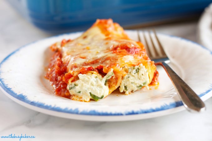 This Baked Ricotta and Spinach Cannelloni is made with three delicious cheeses and it's the perfect easy comfort food recipe that's also vegetarian! It's a pasta lover's dream recipe! Recipe from thebusybaker.ca!