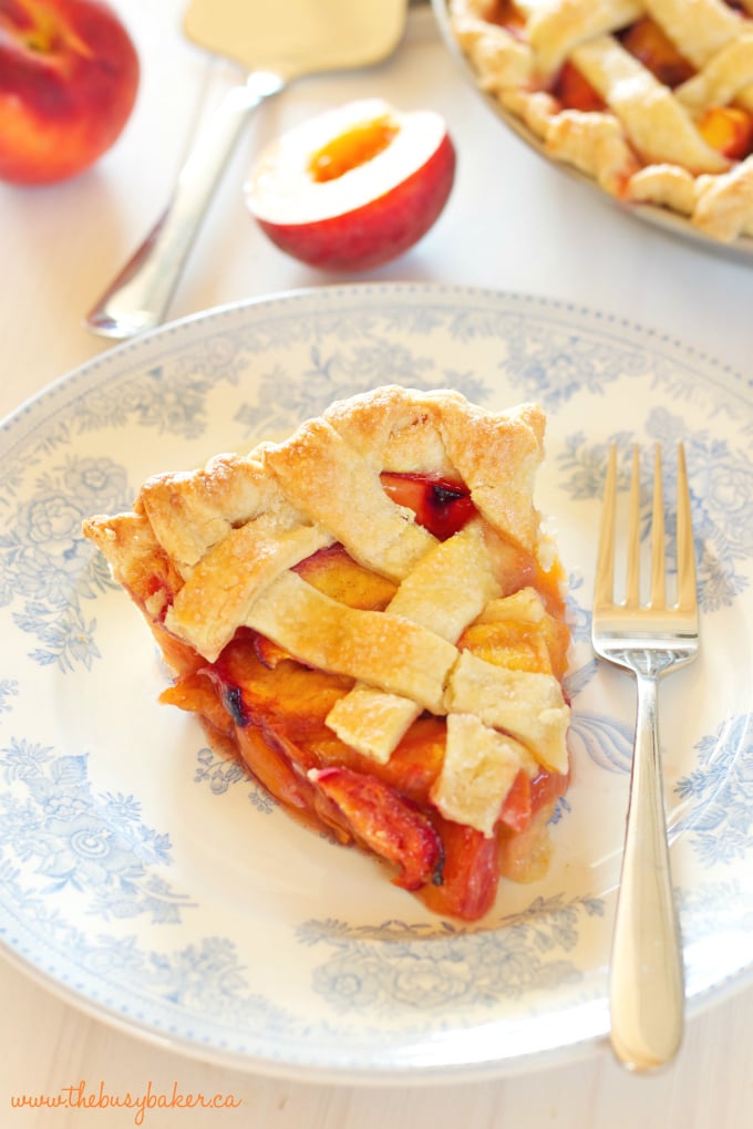 A slice of peach pie on a plate with blue flowers with a fork 