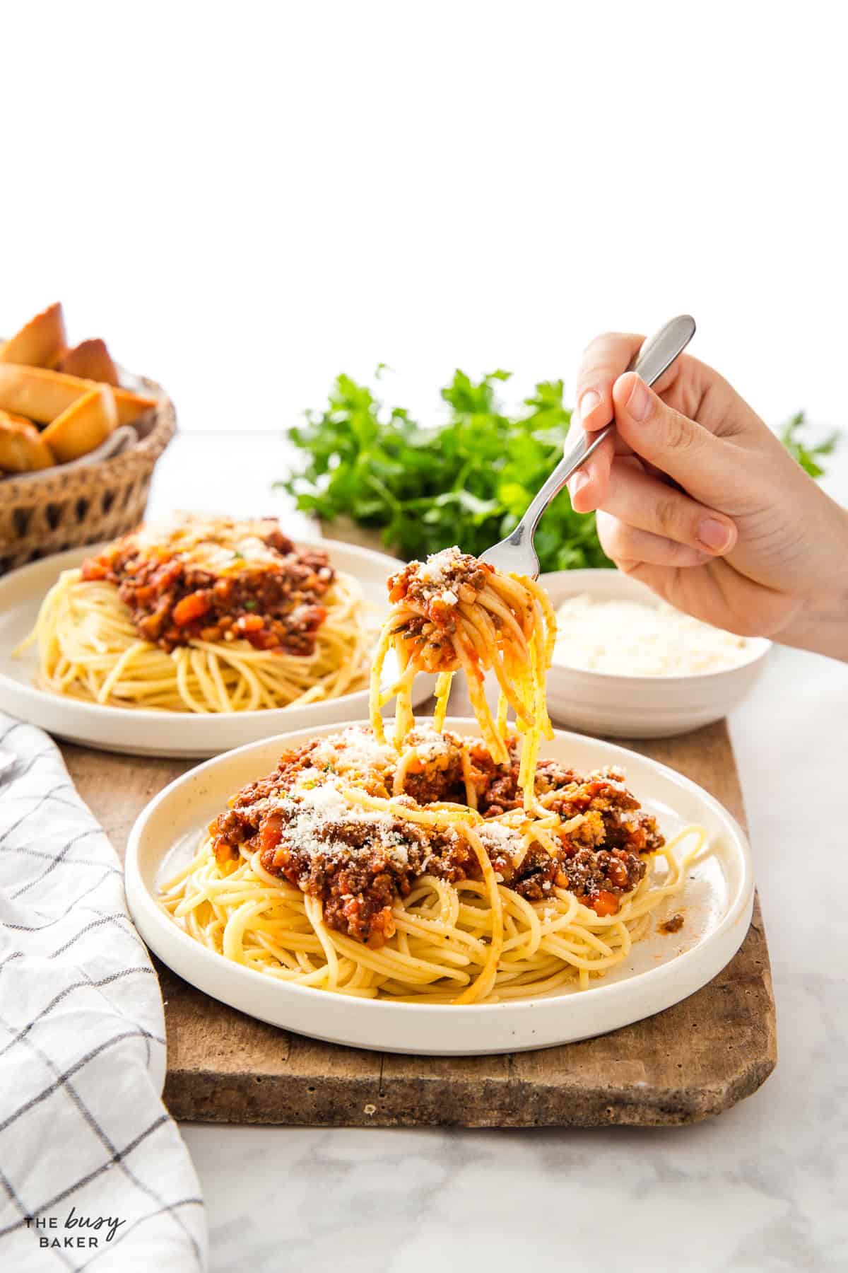 hand holding a forkful of spaghetti and meat sauce