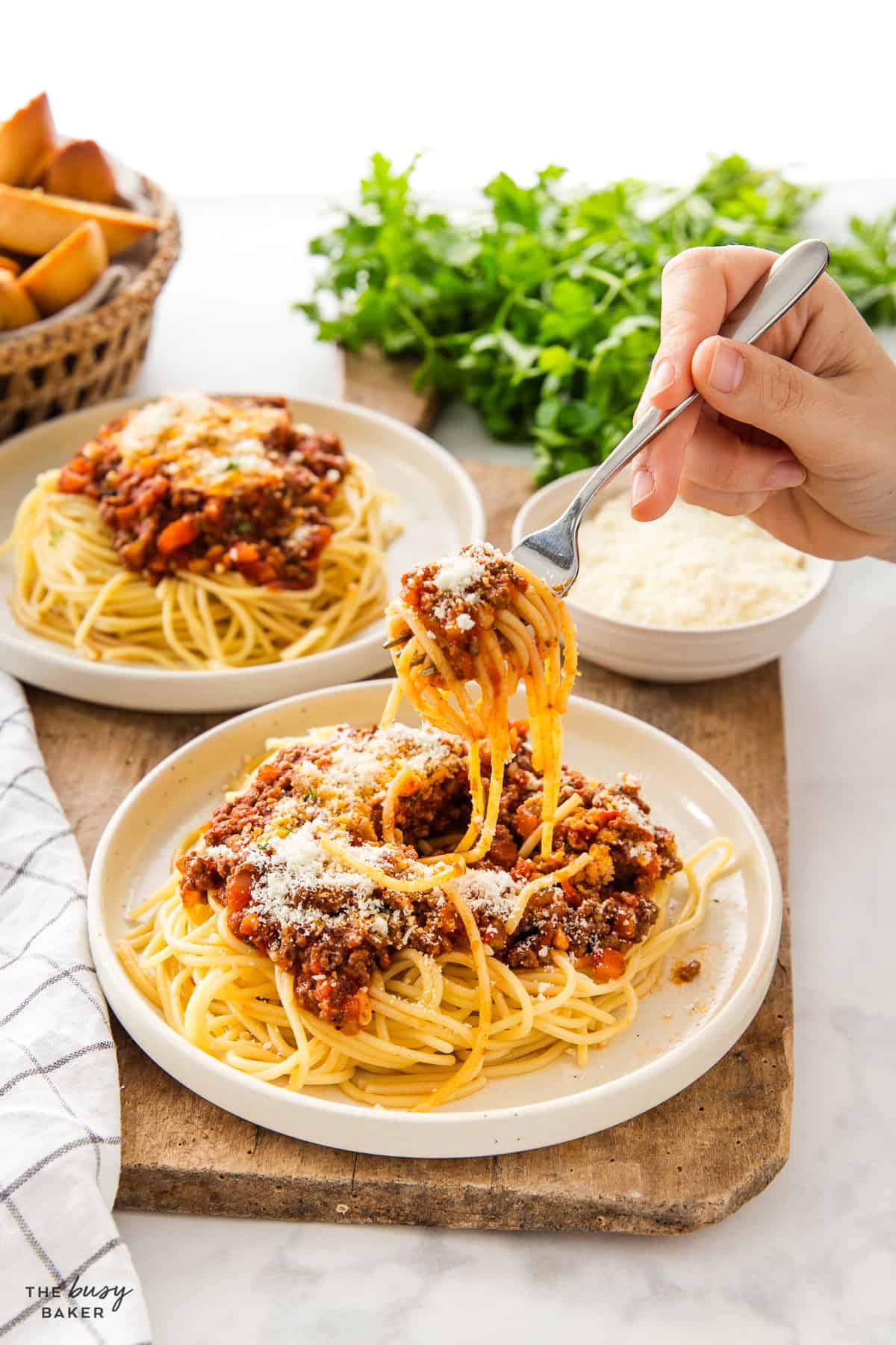 hand twirling pasta with spaghetti sauce and parmesan
