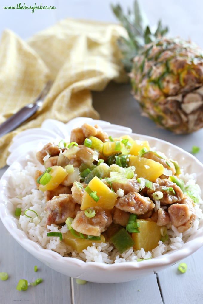 These Pineapple Chicken Rice Bowls make the perfect healthy easy weeknight meal! Made with crispy chicken, fresh veggies, pineapple and a sweet Asian-inspired sauce, they're on the table in 25 minutes or less! Recipe from thebusybaker.ca! #pineapplechicken #easychickenrecipe #pineapplechickenstirfry #asianchicken
