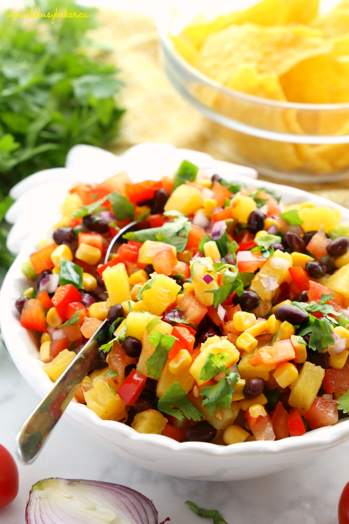 Fresh Pineapple Salsa with chips and spoon in white bowl