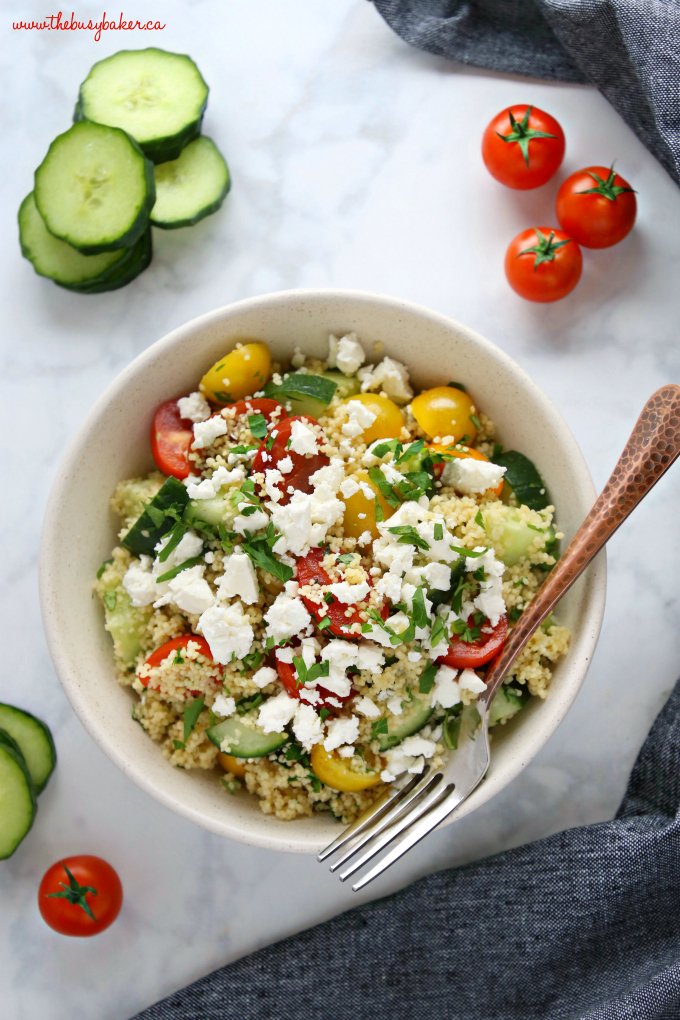 Greek Couscous Salad in pottery bowl with fork and veggies