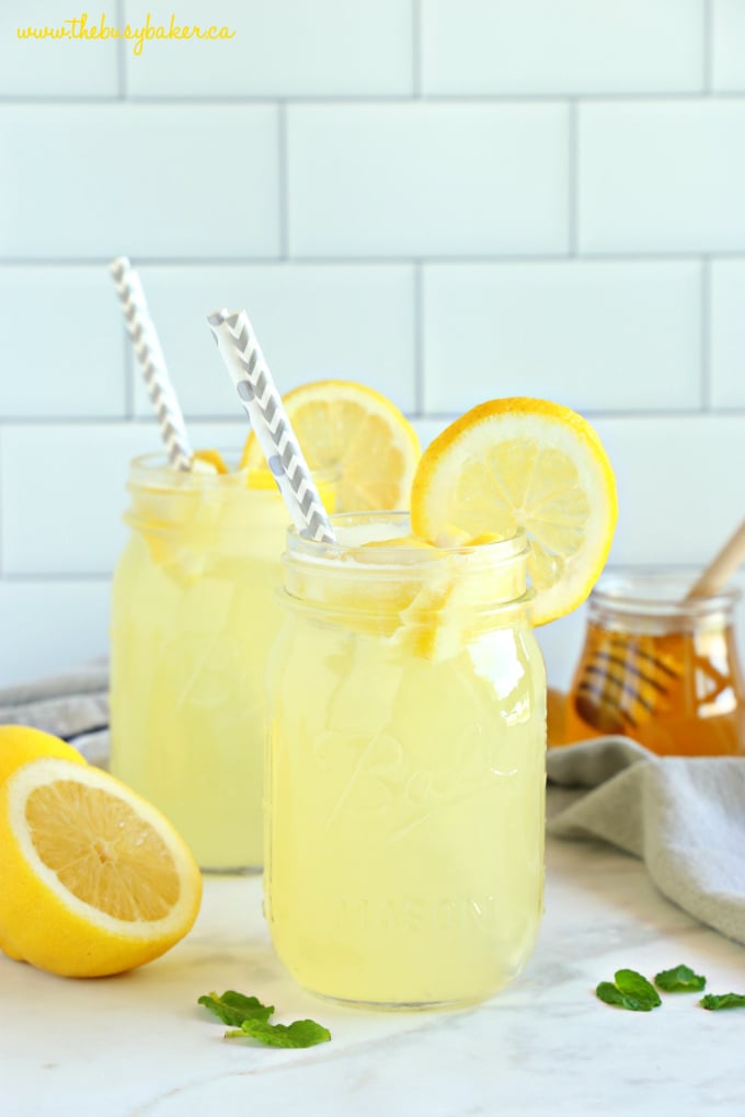 homemade healthy lemonade with paper straws and lemon slices