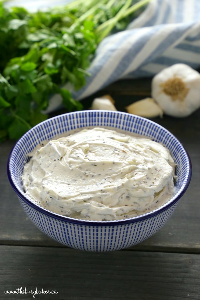Easy Homemade Herb and Garlic Cream Cheese smooth in blue bowl with garlic