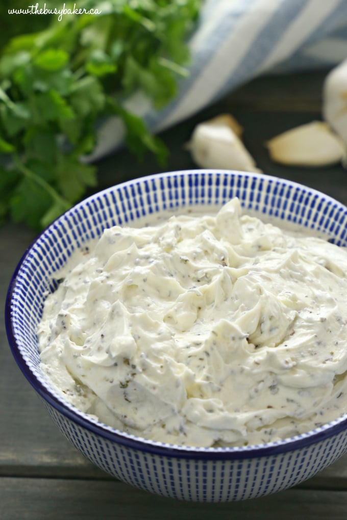 Easy Homemade Herb and Garlic Cream Cheese in blue bowl with parsley and herbs