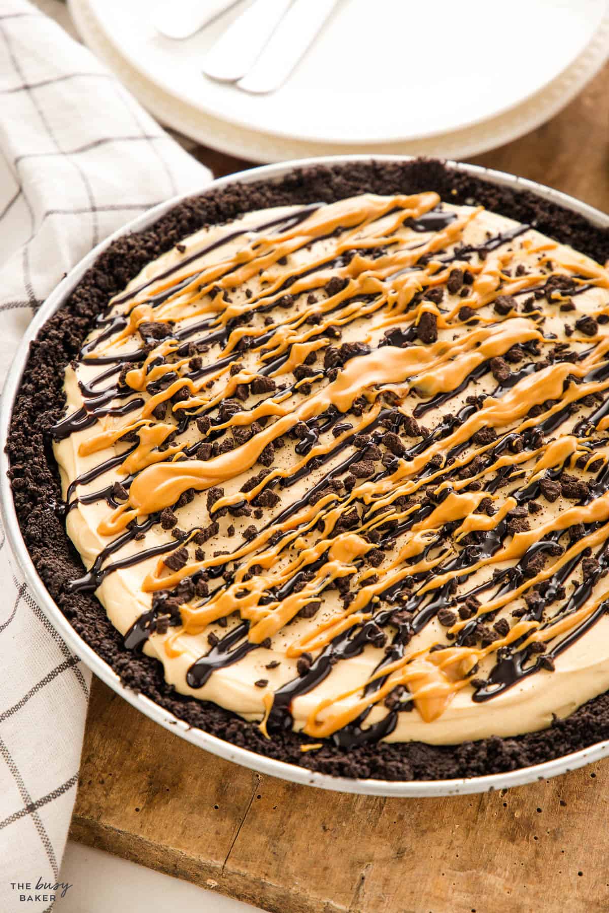 chocolate peanut butter pie topped with chocolate sauce and Oreo crumbs