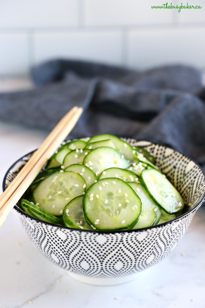Easy Asian Cucumber Salad in black and white bowl with chopsticks in kitchen