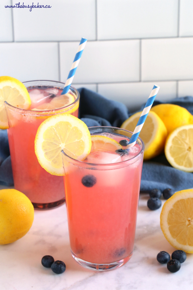 Healthy Blueberry Lemonade in glass with blue striped paper straw