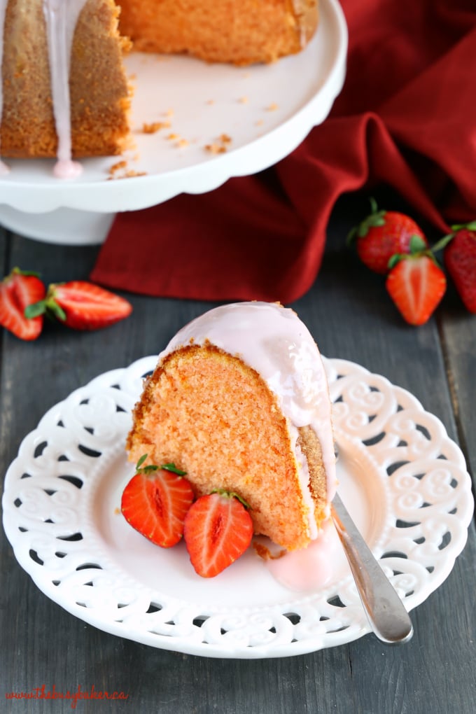 Best Ever Strawberry Pudding Cake on white plate with strawberries