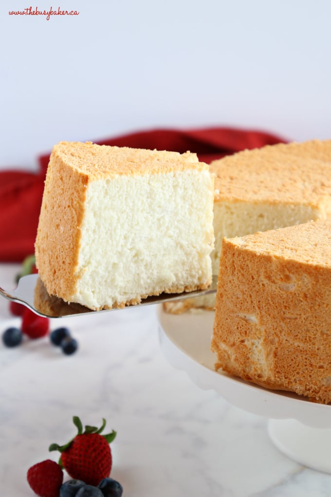 No Fail Homemade Angel Food Cake slice on cake stand with berries