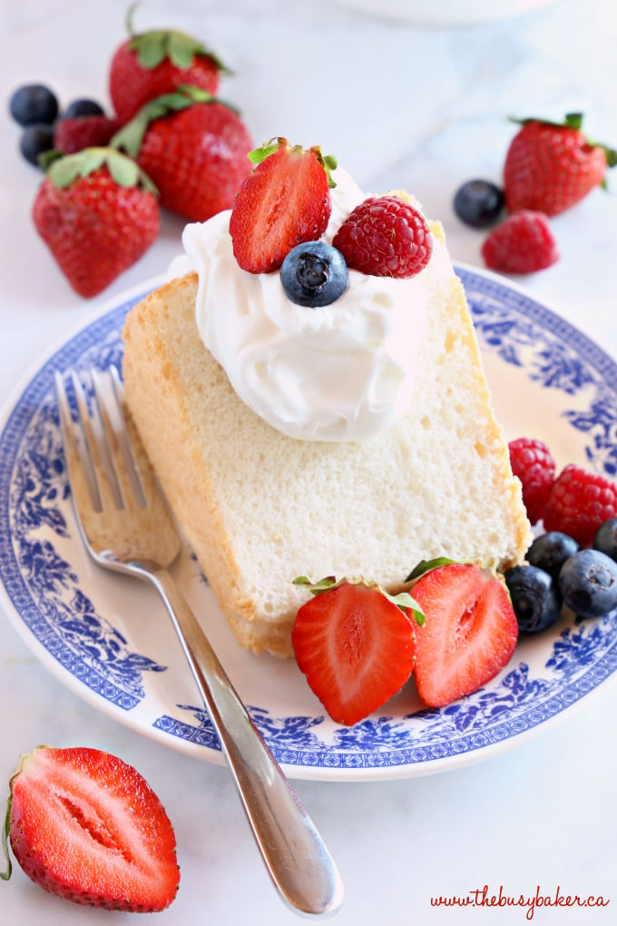 No Fail Homemade Angel Food Cake on blue vintage plate with fruit and whipped cream