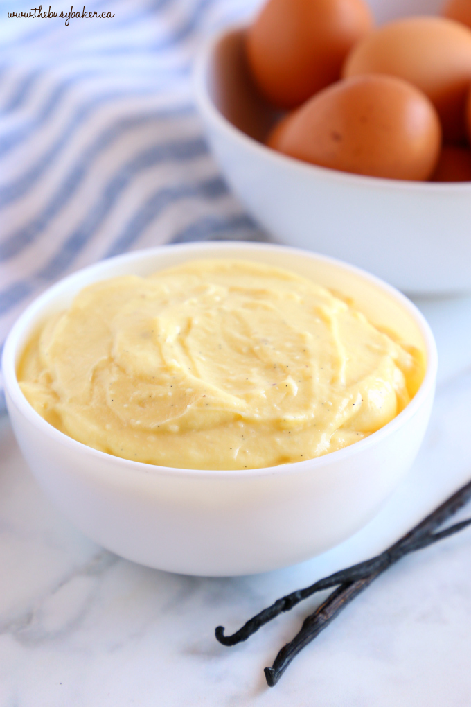 Easy Homemade Vanilla Bean Pastry Cream in white bowl with brown eggs and vanilla beans