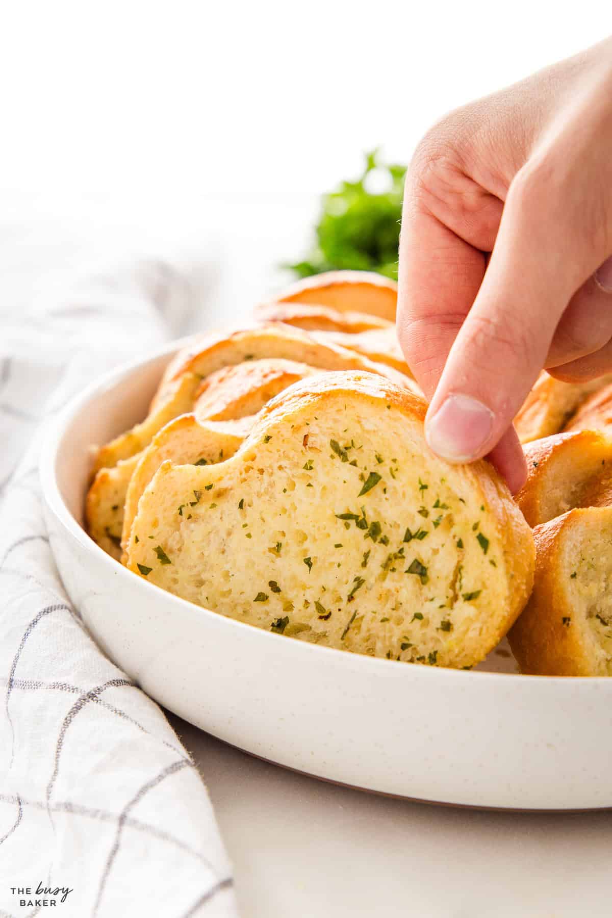 hand holding a piece of garlic bread
