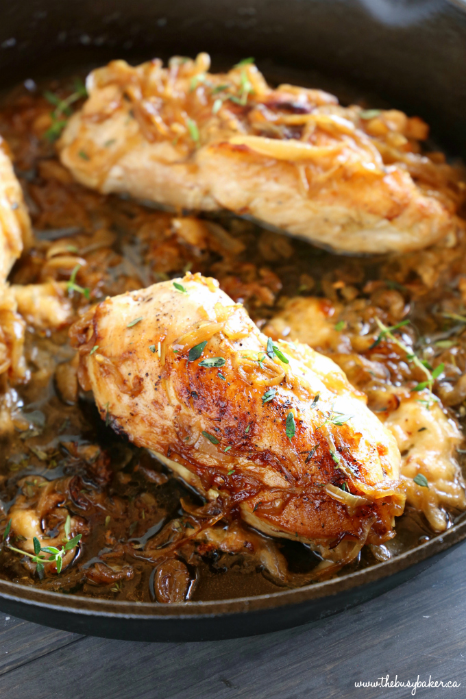Easy One Pan French Onion Stuffed Chicken in cast iron skillet with caramelized onions and fresh thyme