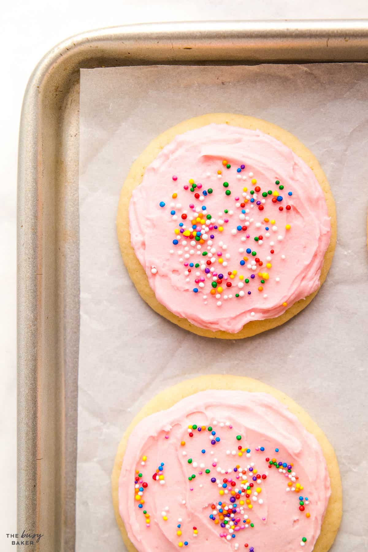 overhead image: frosted sugar cookies on a baking pan