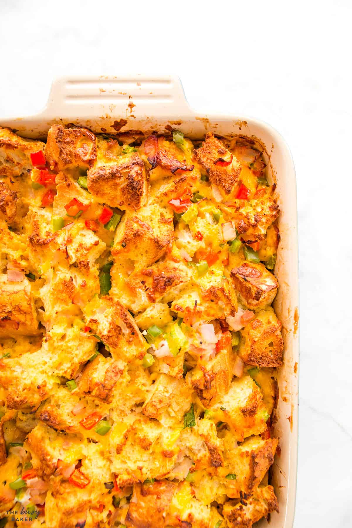 breakfast casserole with bread, veggies, ham, eggs and cheese