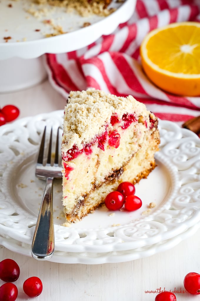 Cranberry Orange Coffee Cake with fresh cranberries and orange slices on white plate with fork