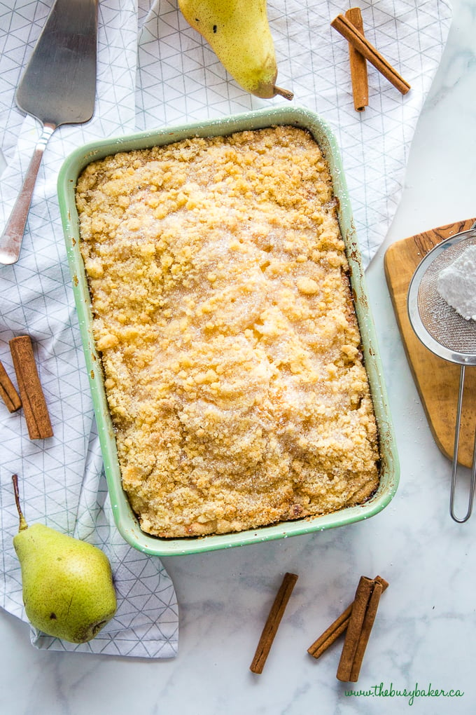 Pear Streusel Cake in green pan with cinnamon sticks