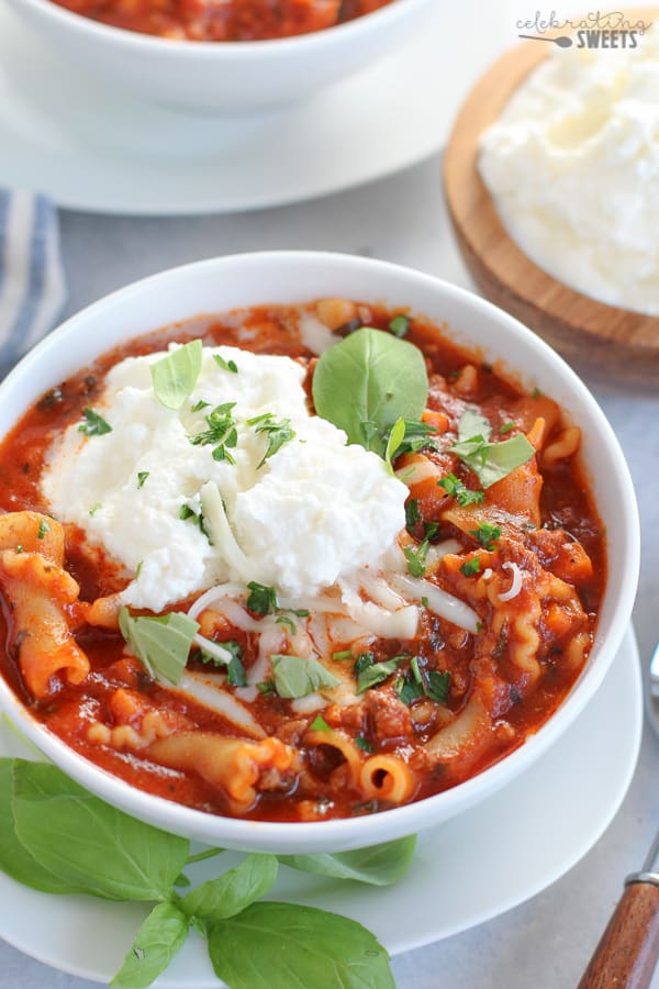 a bowl of lasagna soup topped with ricotta cheese