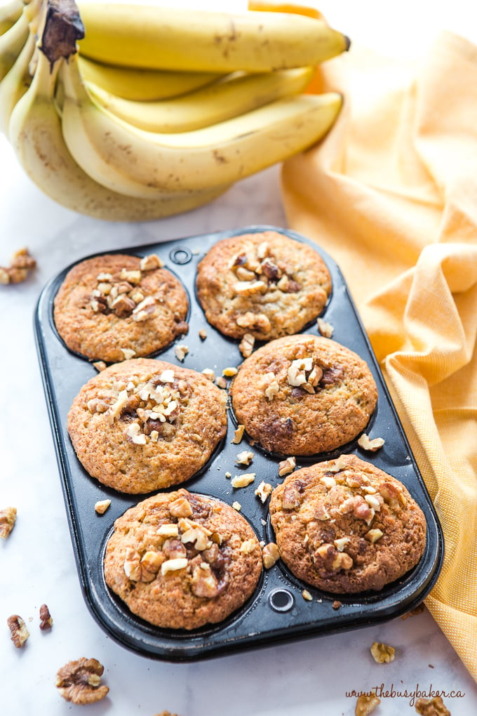Best Ever Banana Nut Muffins in muffin tin with yellow bananas