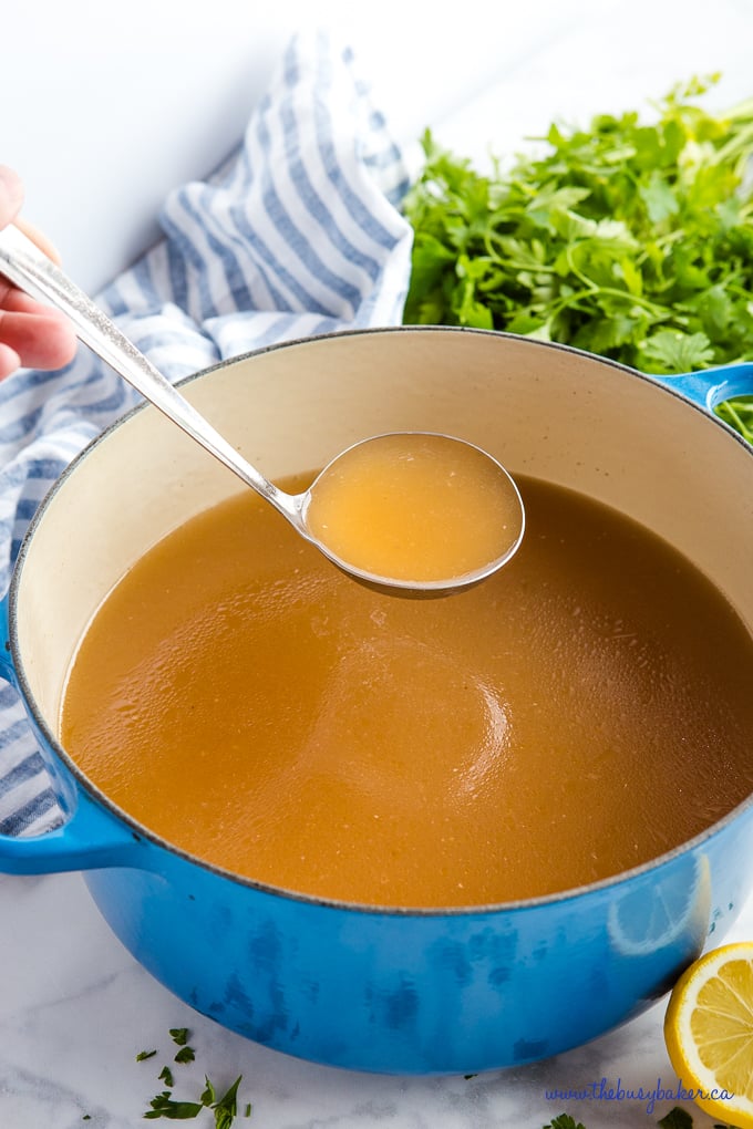Easy Homemade Chicken Stock in blue pot with ladle