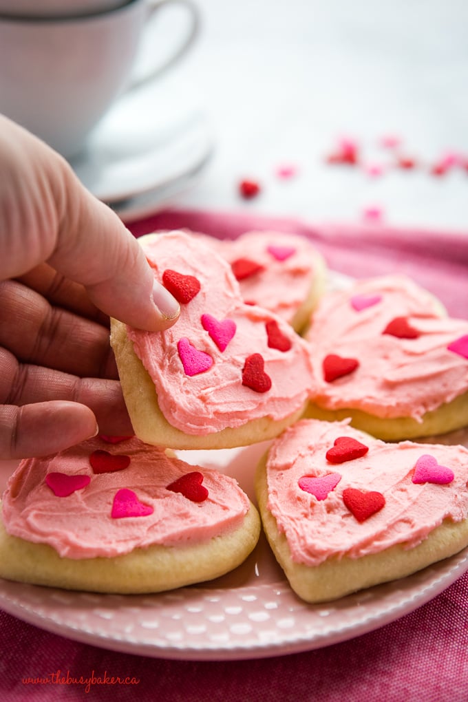 Classic Sour Cream Sugar Cookies with pink frosting and heart sprinkles