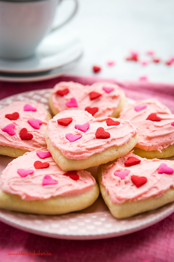 Classic Sour Cream Sugar Cookies with pink frosting and heart sprinkles