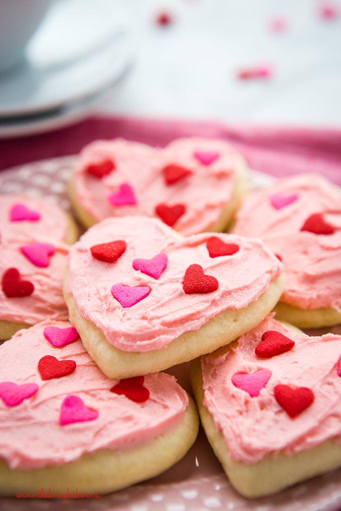 Classic Sour Cream Sugar Cookies on pink plate with heart sprinkles