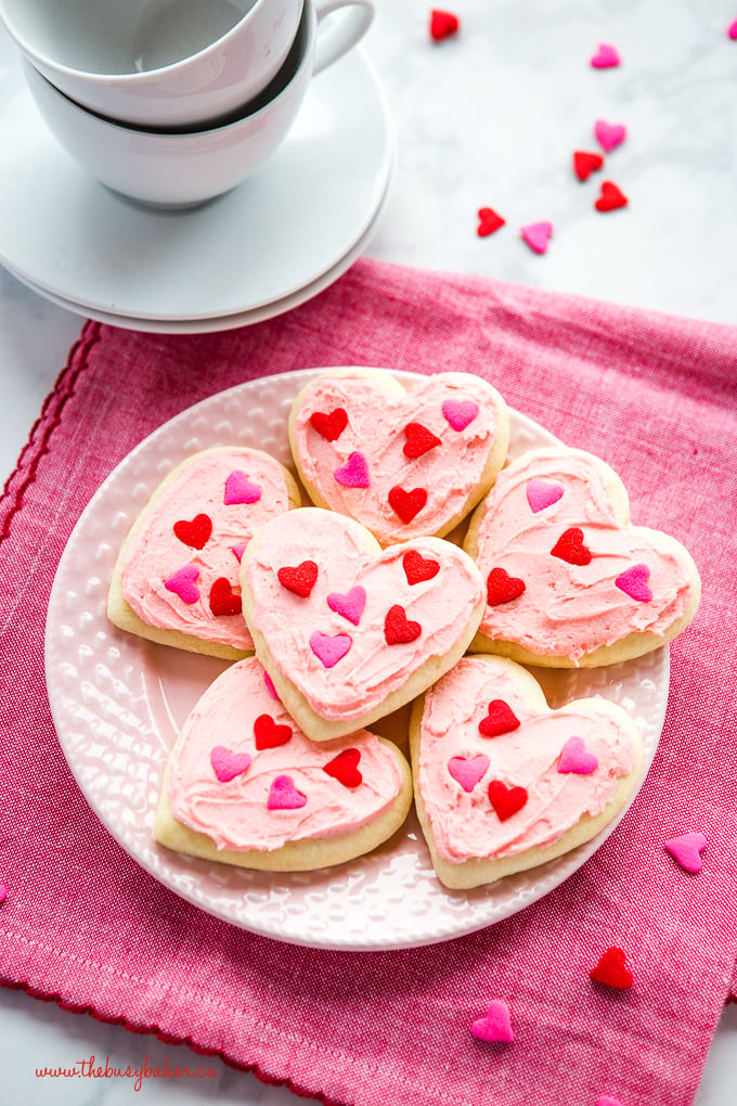 Classic Sour Cream Sugar Cookies on pink plate with heart sprinkles