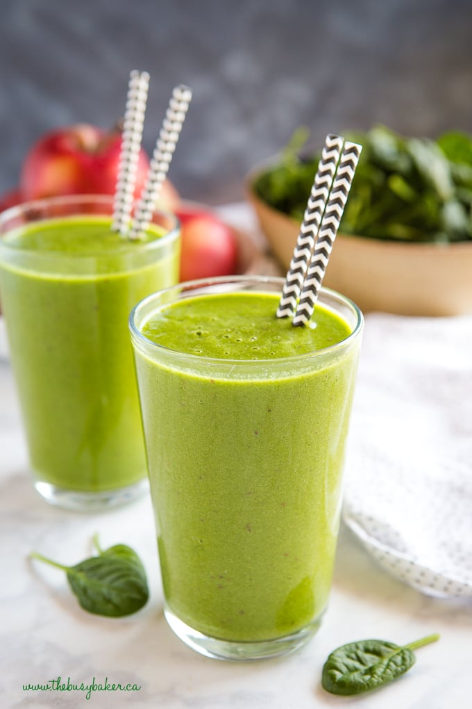 Healthy Green Protein Smoothie in glass with black and white straws