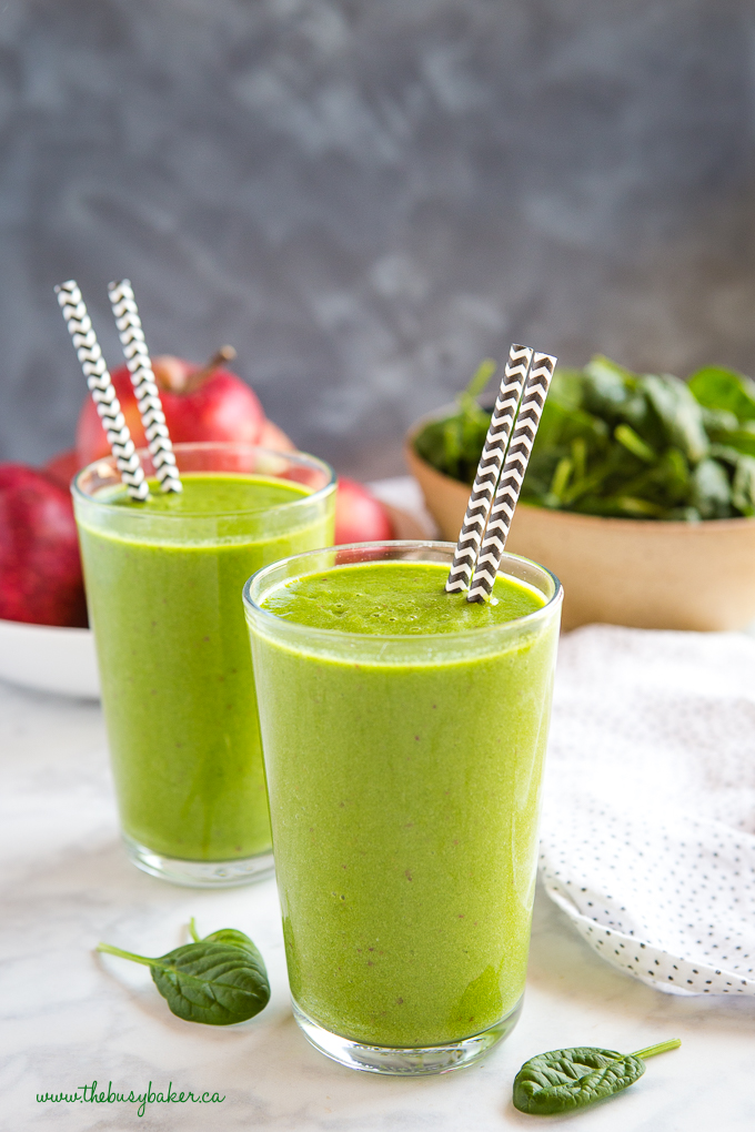 Healthy Green Protein Smoothie with black and white paper straws