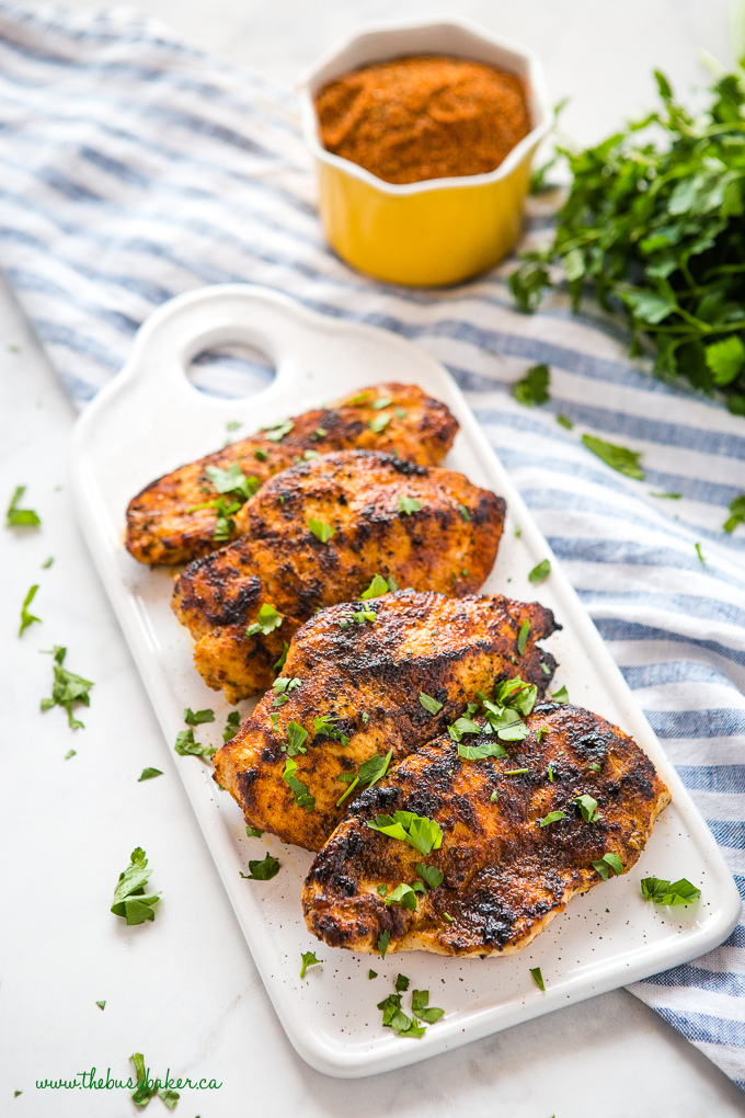 Easy Cajun Grilled Chicken on white tray with yellow bowl of spices