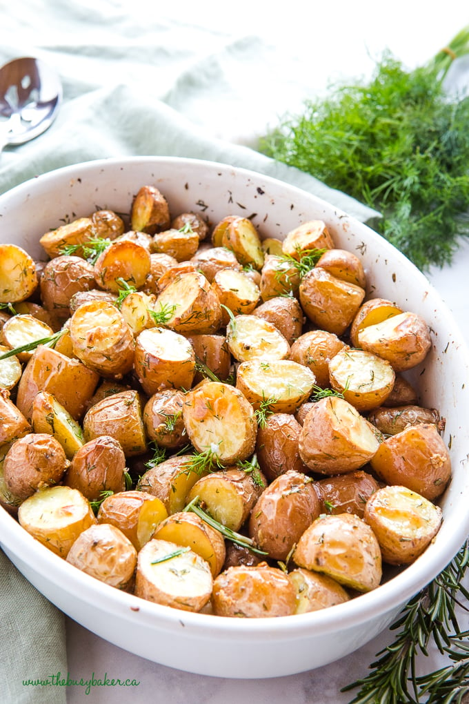 Rosemary Dill Roasted Potatoes in white dish with fresh dill and rosemary