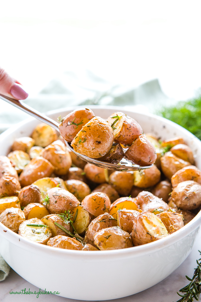Rosemary Dill Roasted Potatoes on spoon with fresh herbs