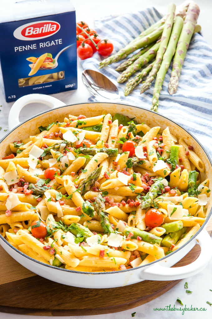 Easy 20-Minute Tomato Asparagus Carbonara Pasta in white casserole dish with fresh veggies and bacon