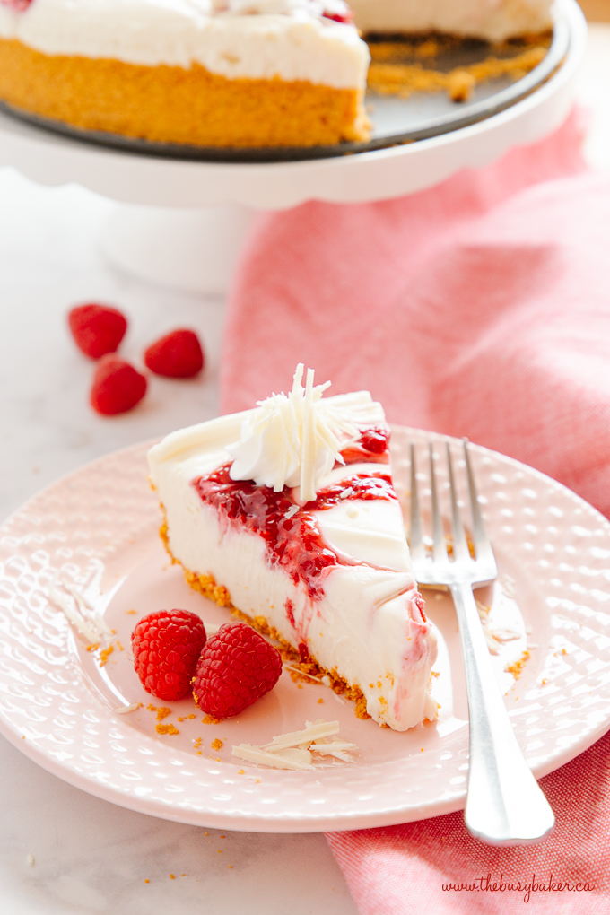 Easy No Bake White Chocolate Raspberry Cheesecake on pink plate with fork