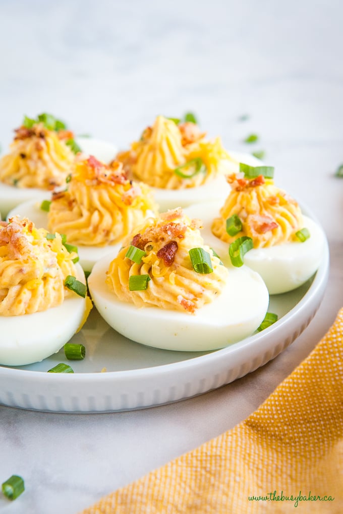 Best Ever Cheddar Bacon Ranch Deviled Eggs on blue plate with green onions