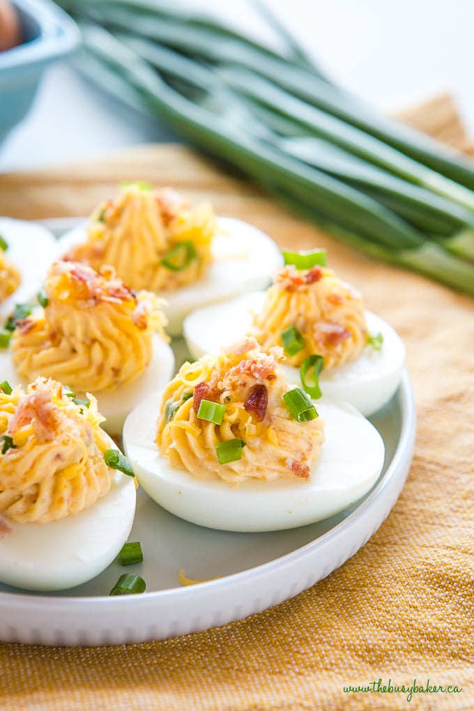 Best Ever Cheddar Bacon Ranch Deviled Eggs on blue plate with green onions