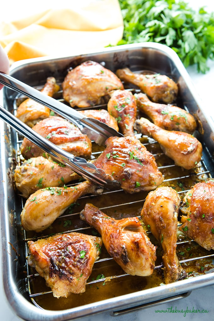 Maple Dijon Roasted Chicken with sticky glaze in roasting pan with fresh herbs