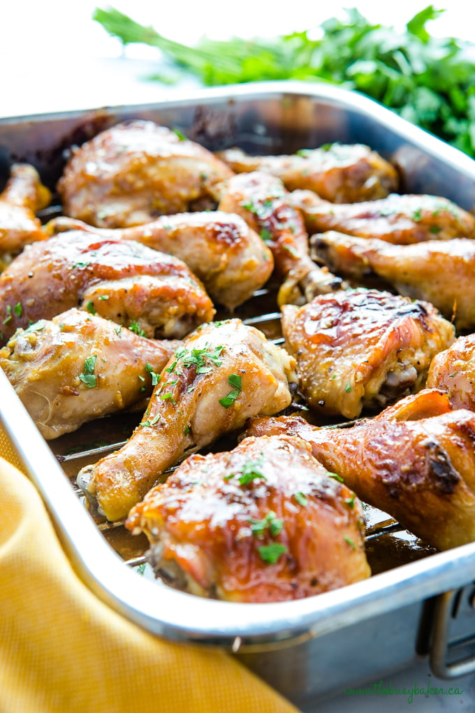 Maple Dijon Roasted Chicken with sticky glaze in roasting pan with fresh herbs