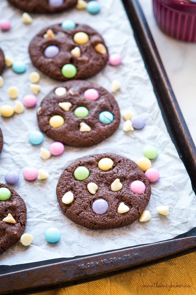 These Easter Double Chocolate Cookies are the perfect fun and easy Easter treat! Crispy on the outside, chewy on the inside, and packed with candy-coated chocolate and white chocolate! Easter Double Chocolate Cookies with Spring M&Ms on baking sheet