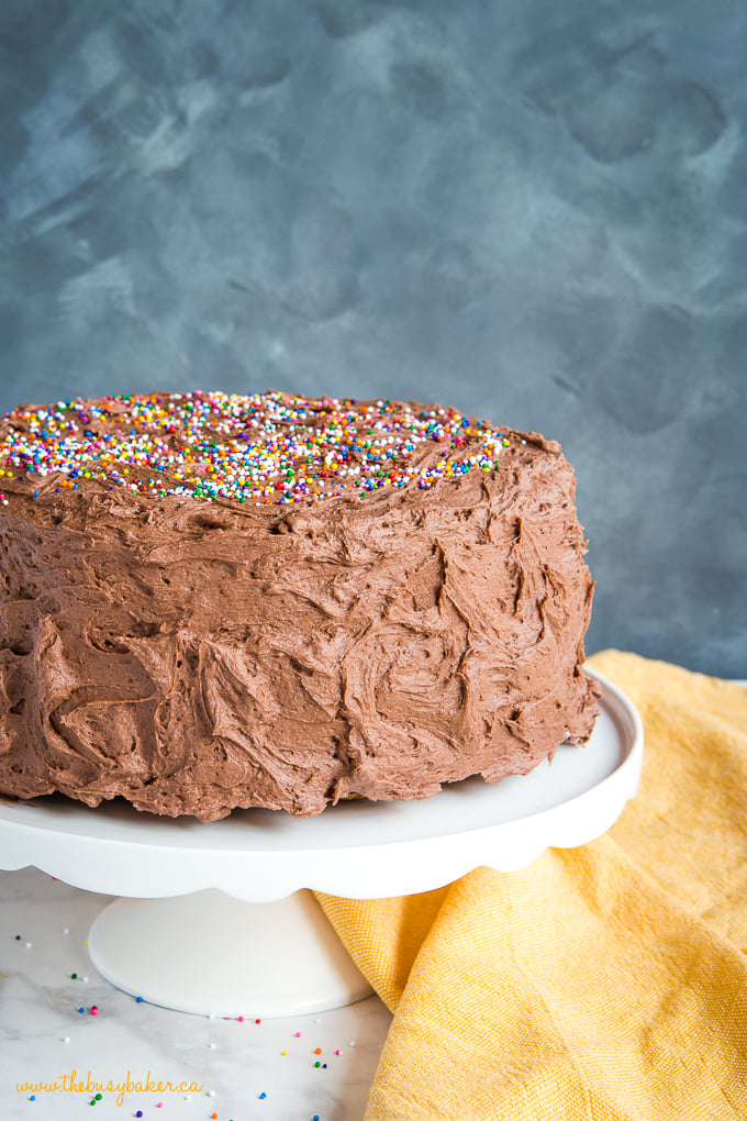 Banana Birthday Cake with Chocolate Frosting on white cake stand