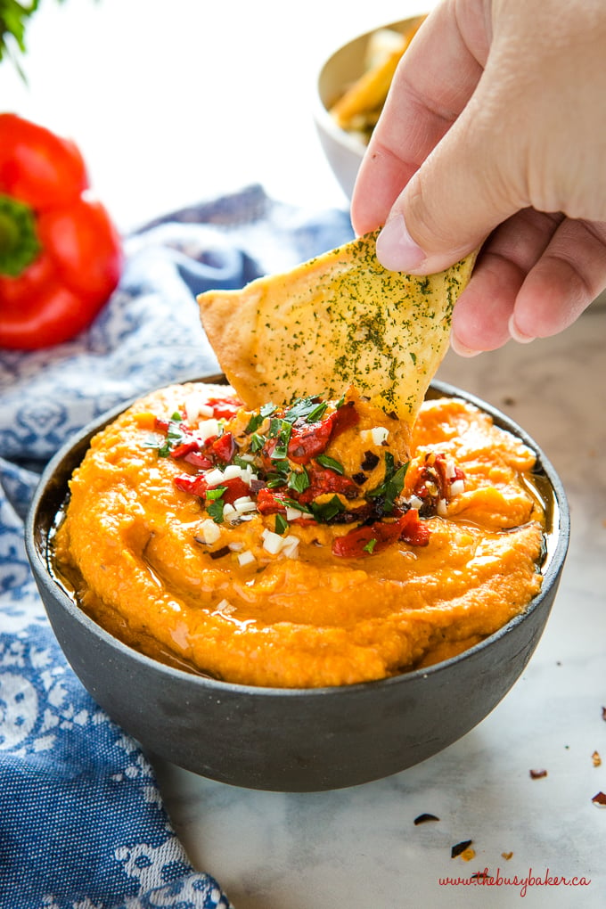 Roasted Red Pepper Hummus in black bowl with pita chips