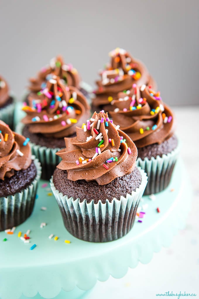 chocolate cupcake recipe made from scratch- swirls of chocolate buttercream frosting and colored sprinkles on cupcakes 