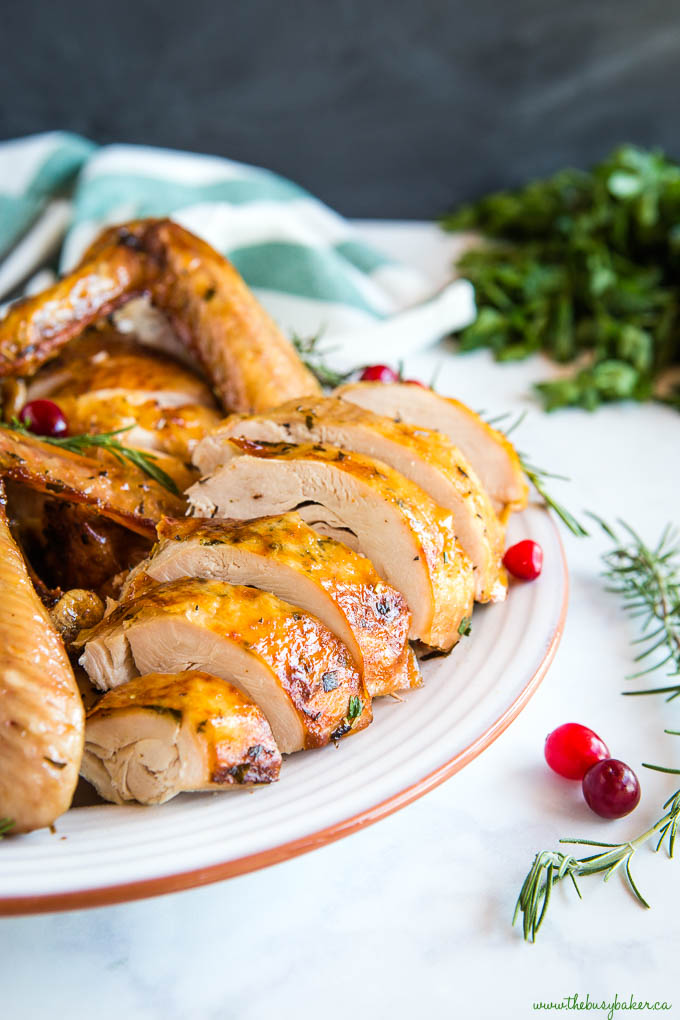 juicy roasted turkey on terra cotta plate with cranberries and rosemary