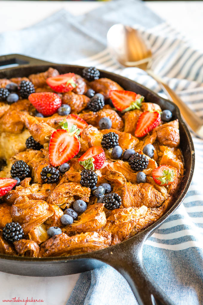 baked breakfast casserole topped with berries in cast iron skillet