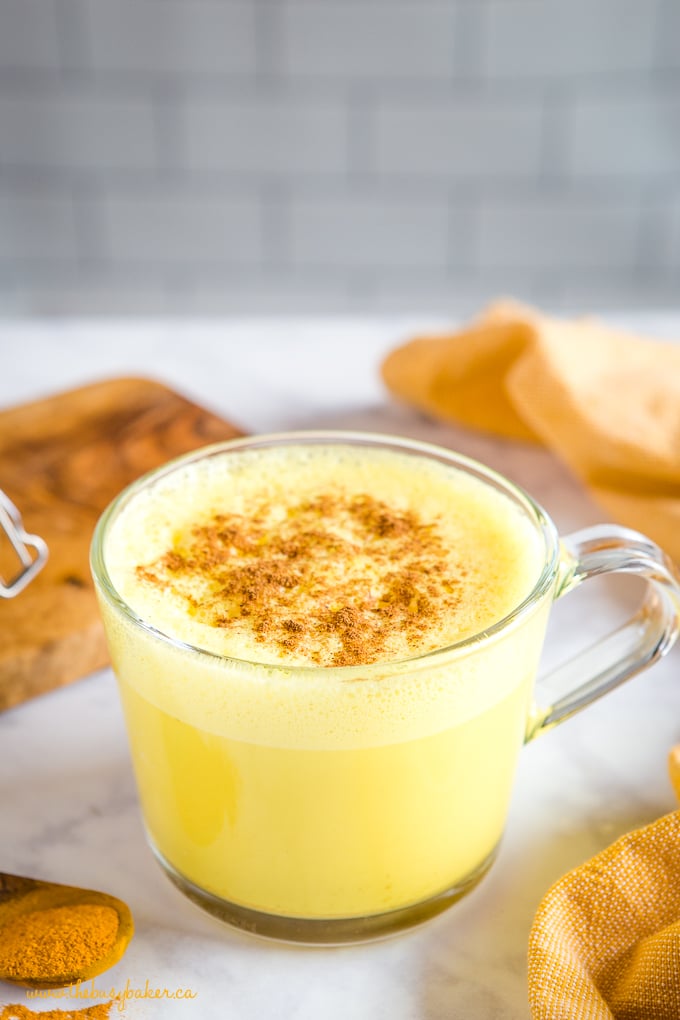 healthy yellow colored milk beverage in glass mug