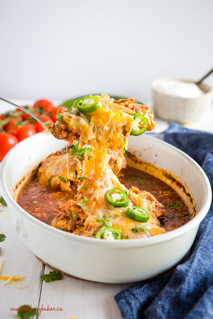 serving salsa baked chicken with cheese and jalapenos from white casserole dish